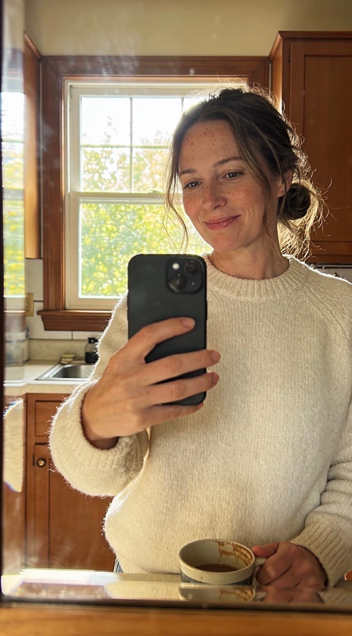 Anna taking a mirror selfie in a sunlit kitchen